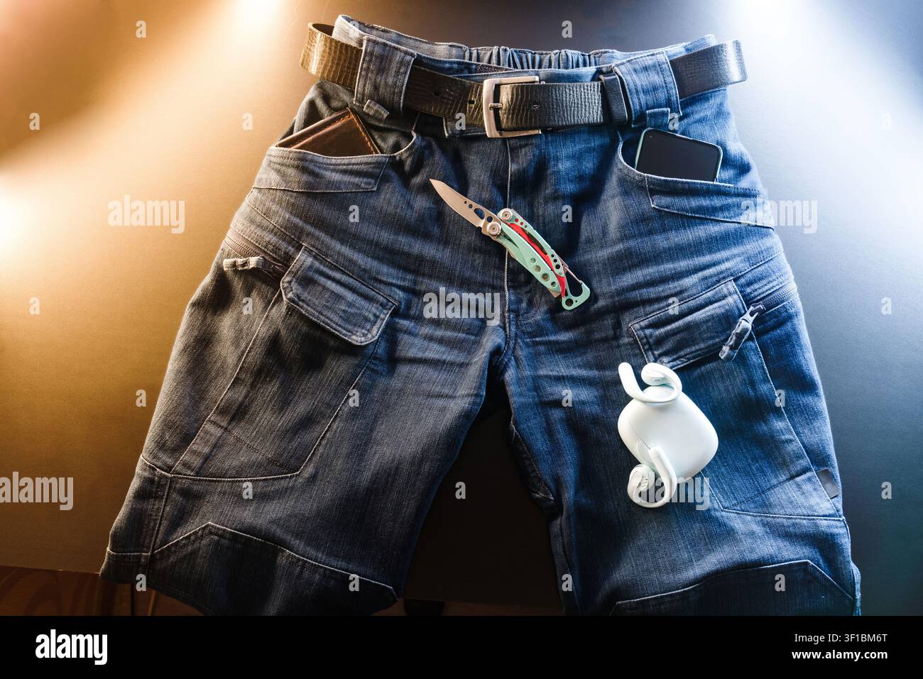 Taktische Jeans EDC Flat Lay mit Multitool, Kopfhörern und Smartphone. Stockfoto