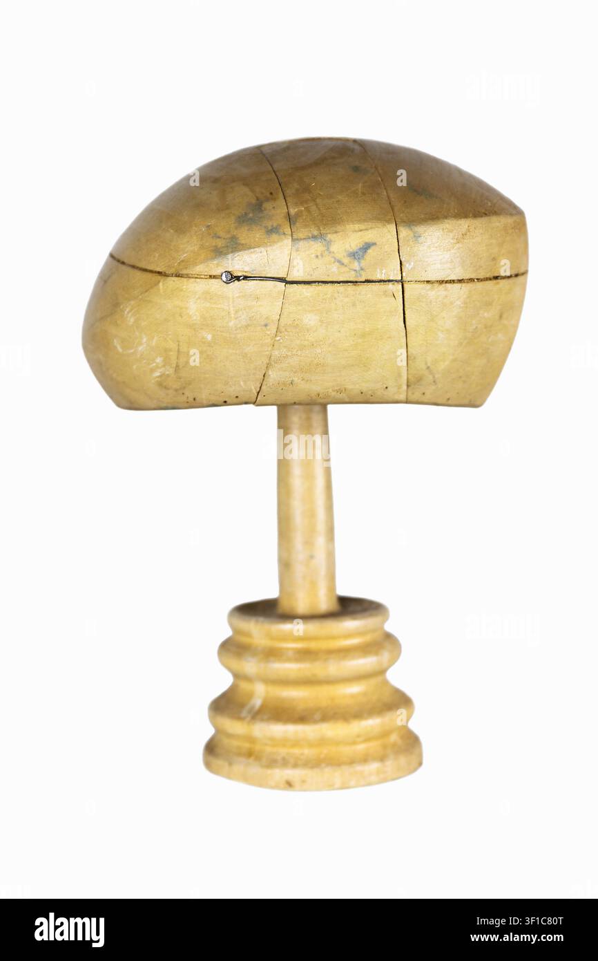 Antike Hutmacherei-Form zum Formen von Baskenmützen und Hüten auf einem Ständer. Vintage-Holzblock. Handwerkskunst, alte Berufe, Handwerkskonzept. Isoliert auf Stockfoto