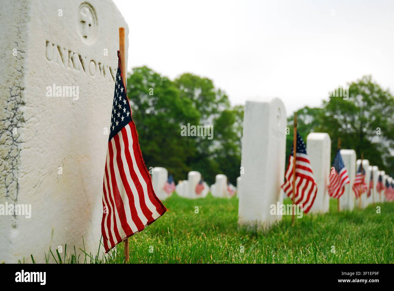 Amerikanische Flaggen werden am Gedenktag vor den Gräbern unbekannter Soldaten auf einem nationalen Militärfriedhof platziert Stockfoto