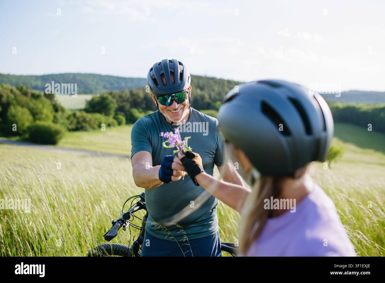 Seniorenpaar, die während einer E-Bike-Fahrt durch die Landschaft eine Pause machen Stockfoto
