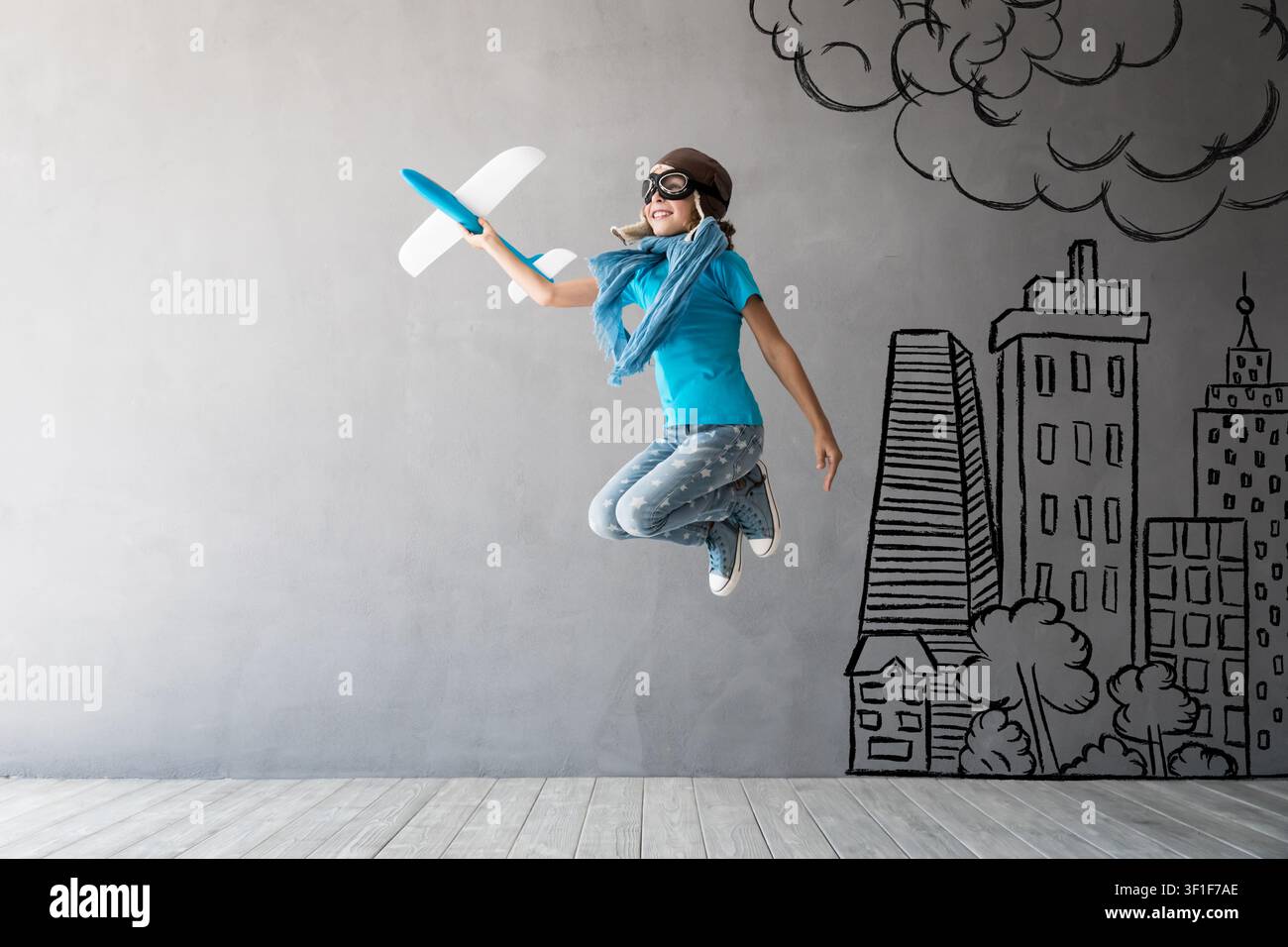 Kindpilot springt. Kind hat Spaß zu Hause. Erfolg, kreatives und Ideenkonzept Stockfoto