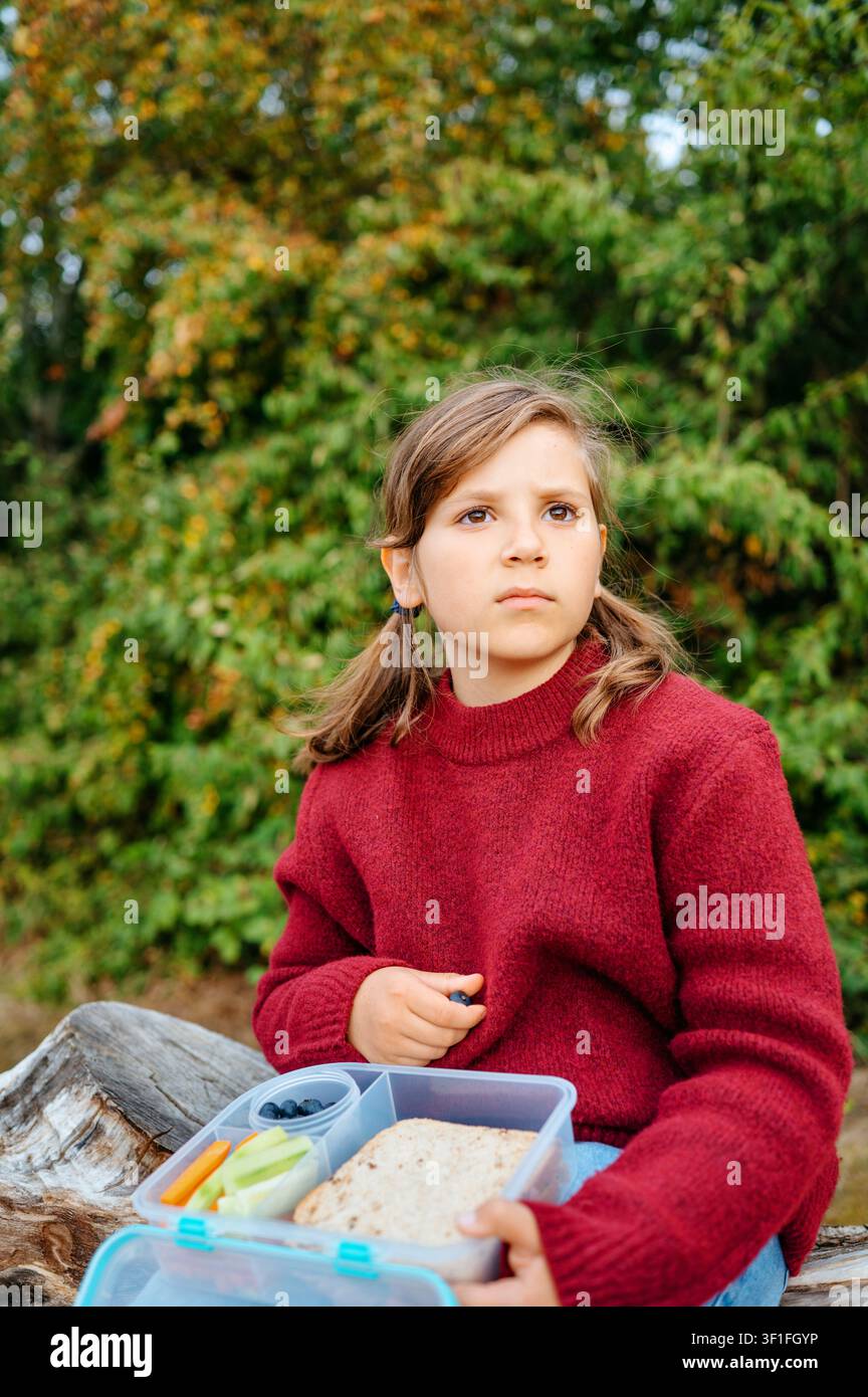 Schulmädchen hält ein gesundes Lunchpaket im Freien Stockfoto