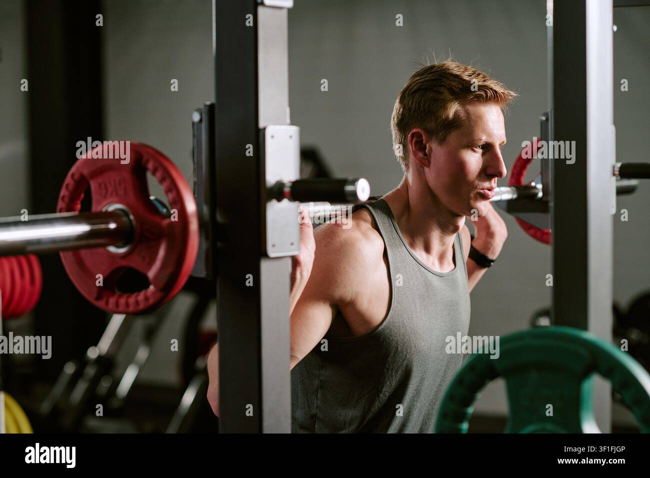 Mann führt im Fitnessstudio Barbell-Squat-Training für Fitness durch Stockfoto