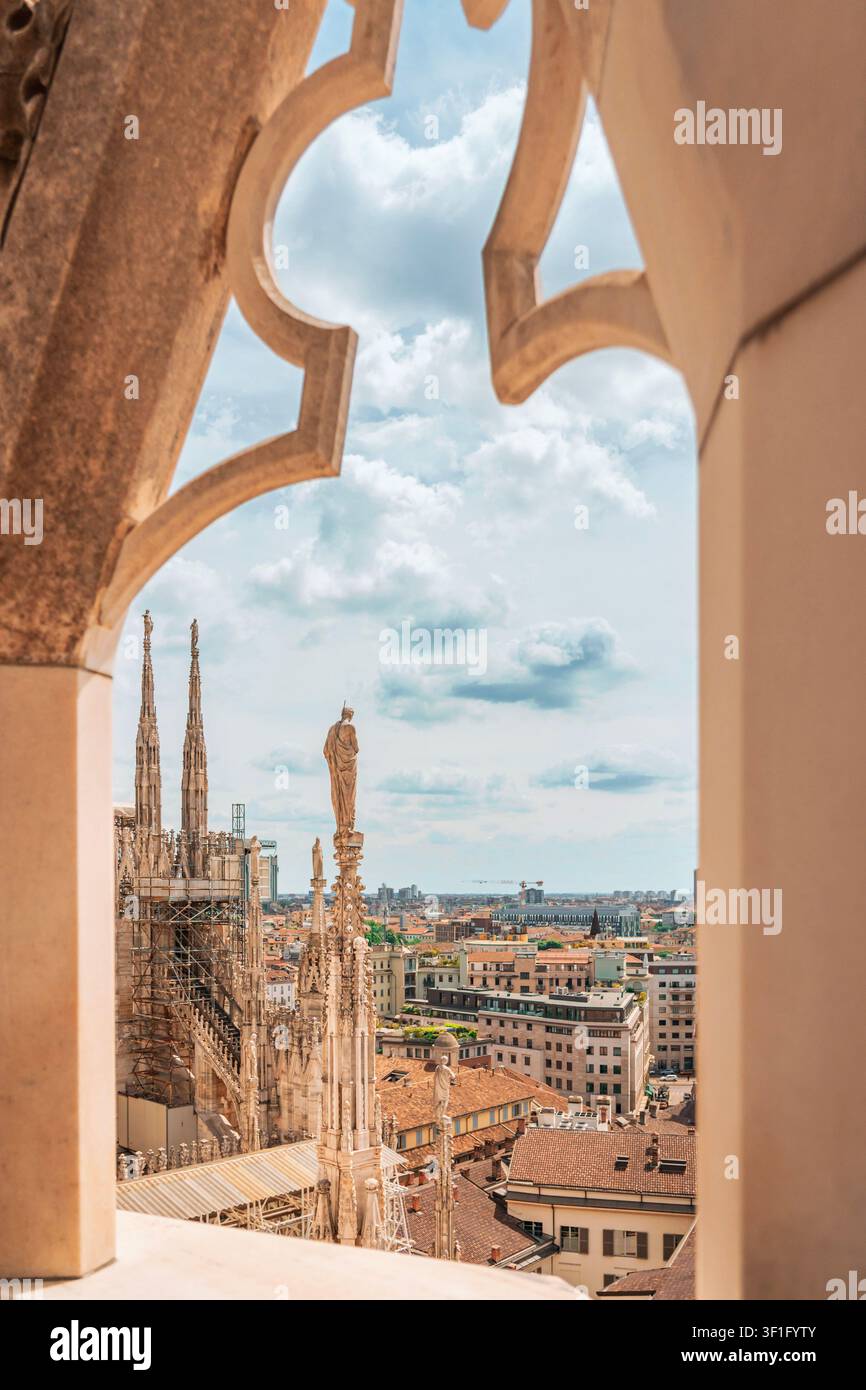 Panoramablick auf die Dächer von Mailand, eingerahmt von einem gotischen Marmorkathedralbogen. Stockfoto