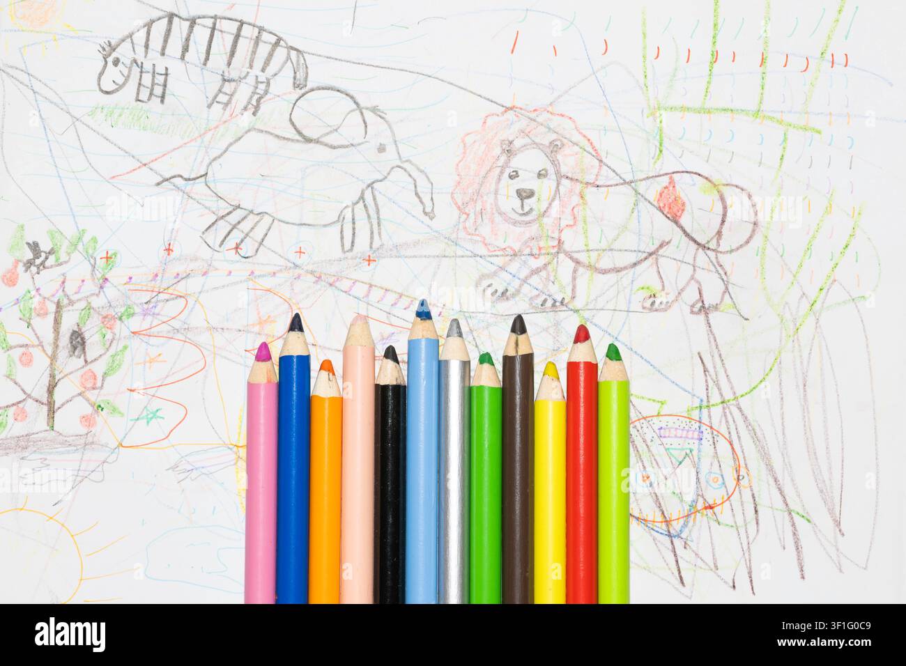Buntstifte zum Zeichnen auf weißem Papier mit Kinderzeichnungen. Stockfoto