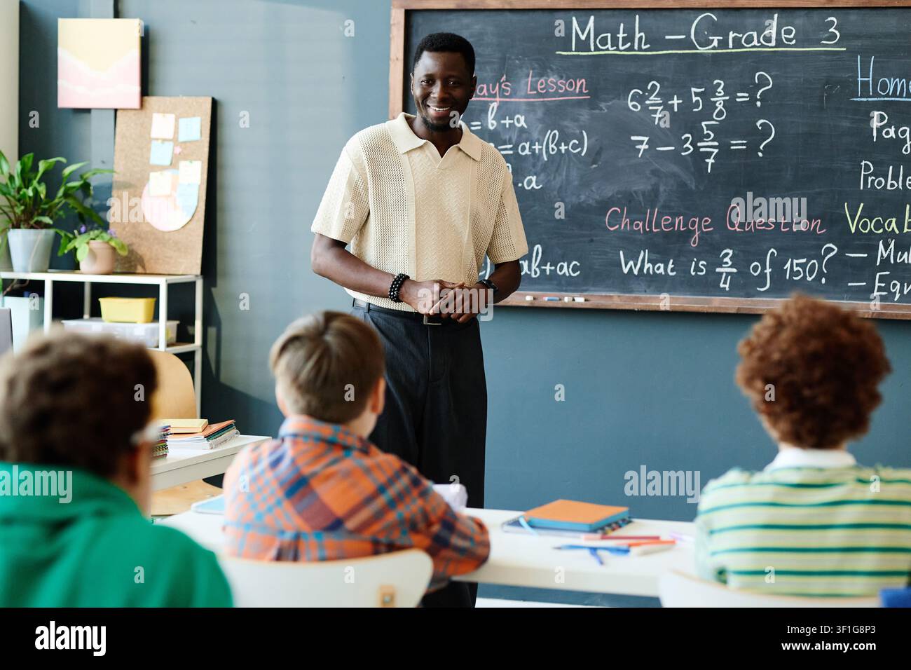 Porträt eines schwarzen Mannes, der Kindern im Klassenzimmer Mathe beibringt Stockfoto