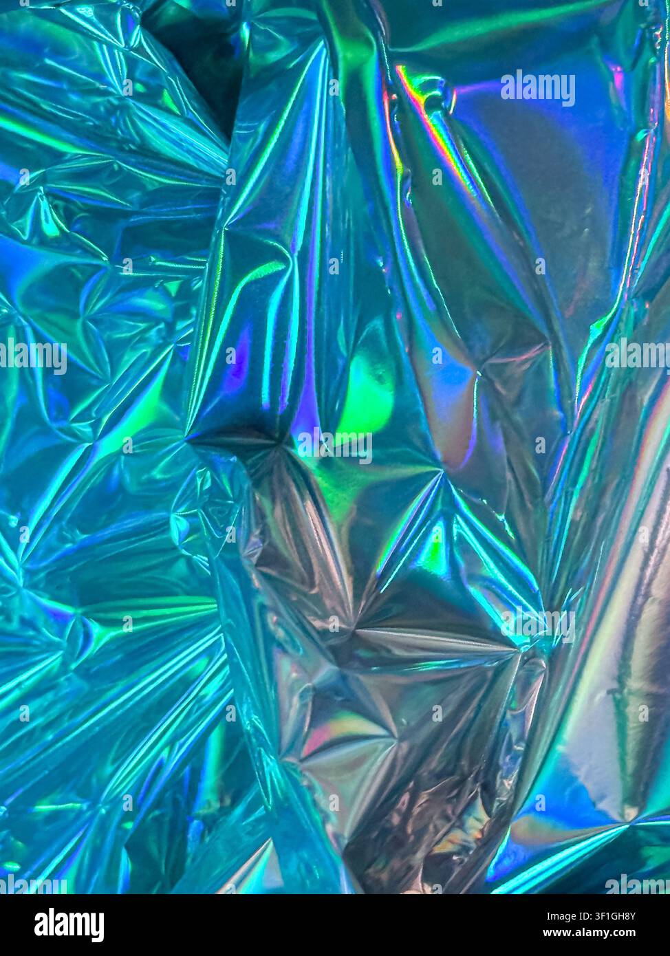 Abstraktes schimmerndes Textilmaterial mit irisierender Oberfläche. Lebendige cyan und grüne Farbpalette, die eine futuristische und energetische Stimmung erzeugt, geeignet für Stockfoto
