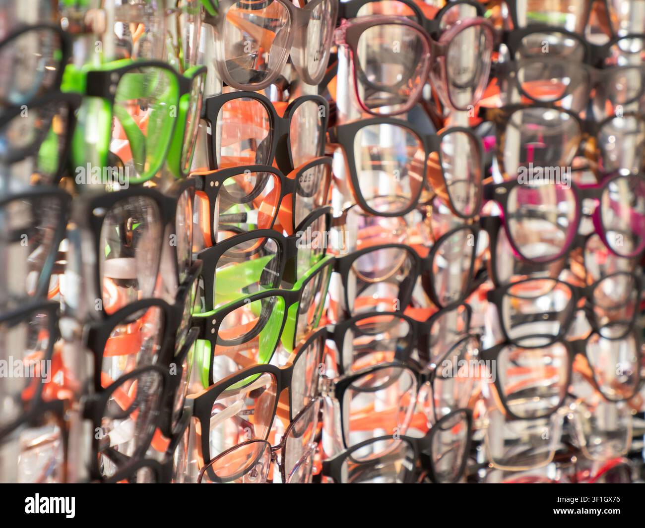 Vitrine mit Brillen mit Dioptrien hängt in mehreren Reihen an einer Wand. Stockfoto