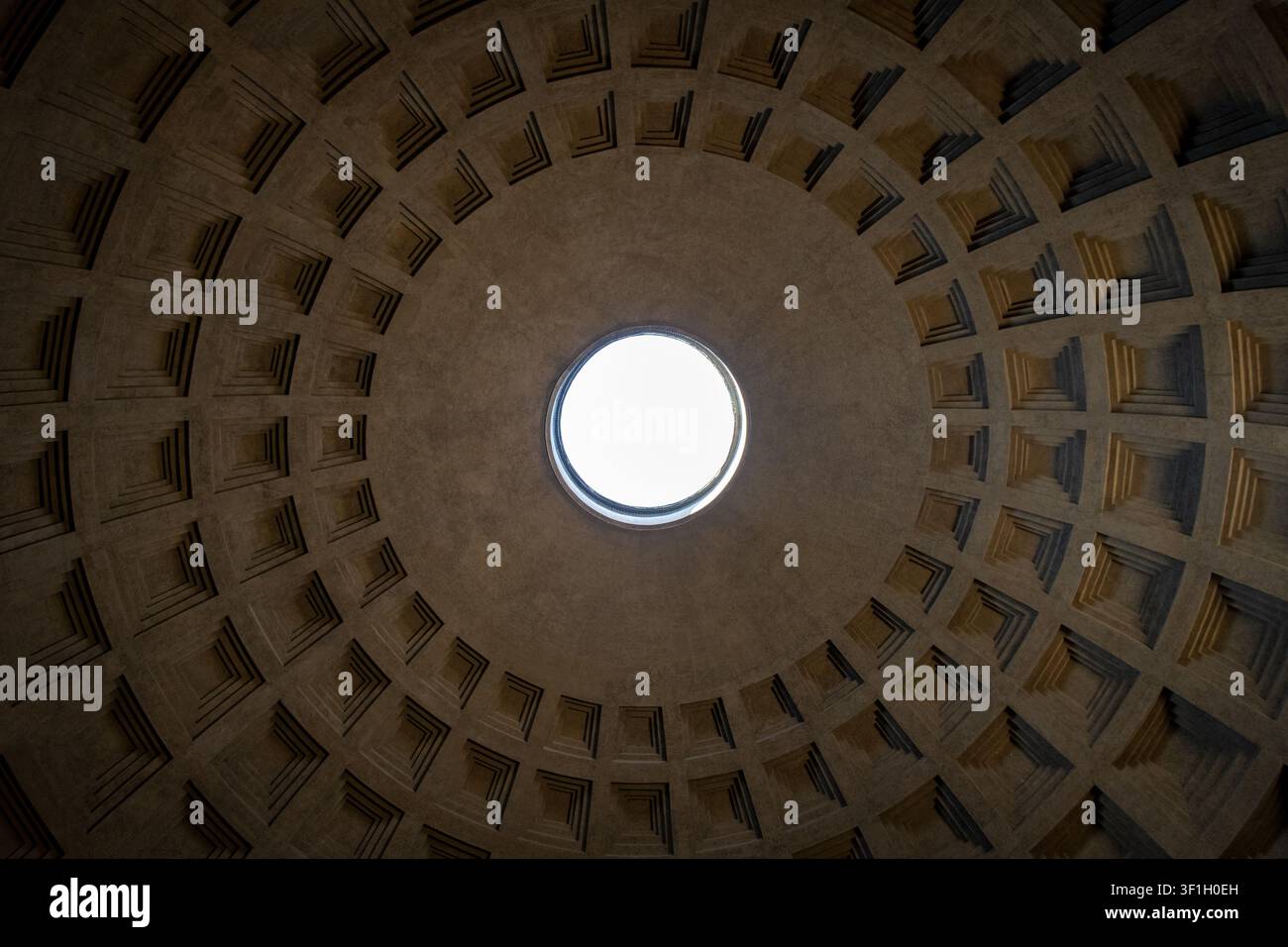 Symmetrische Niedrigwinkelaufnahme, die direkt nach oben auf das Oculus und die Kassettenkuppel des Pantheons in Rom, Italien, gerichtet ist Stockfoto