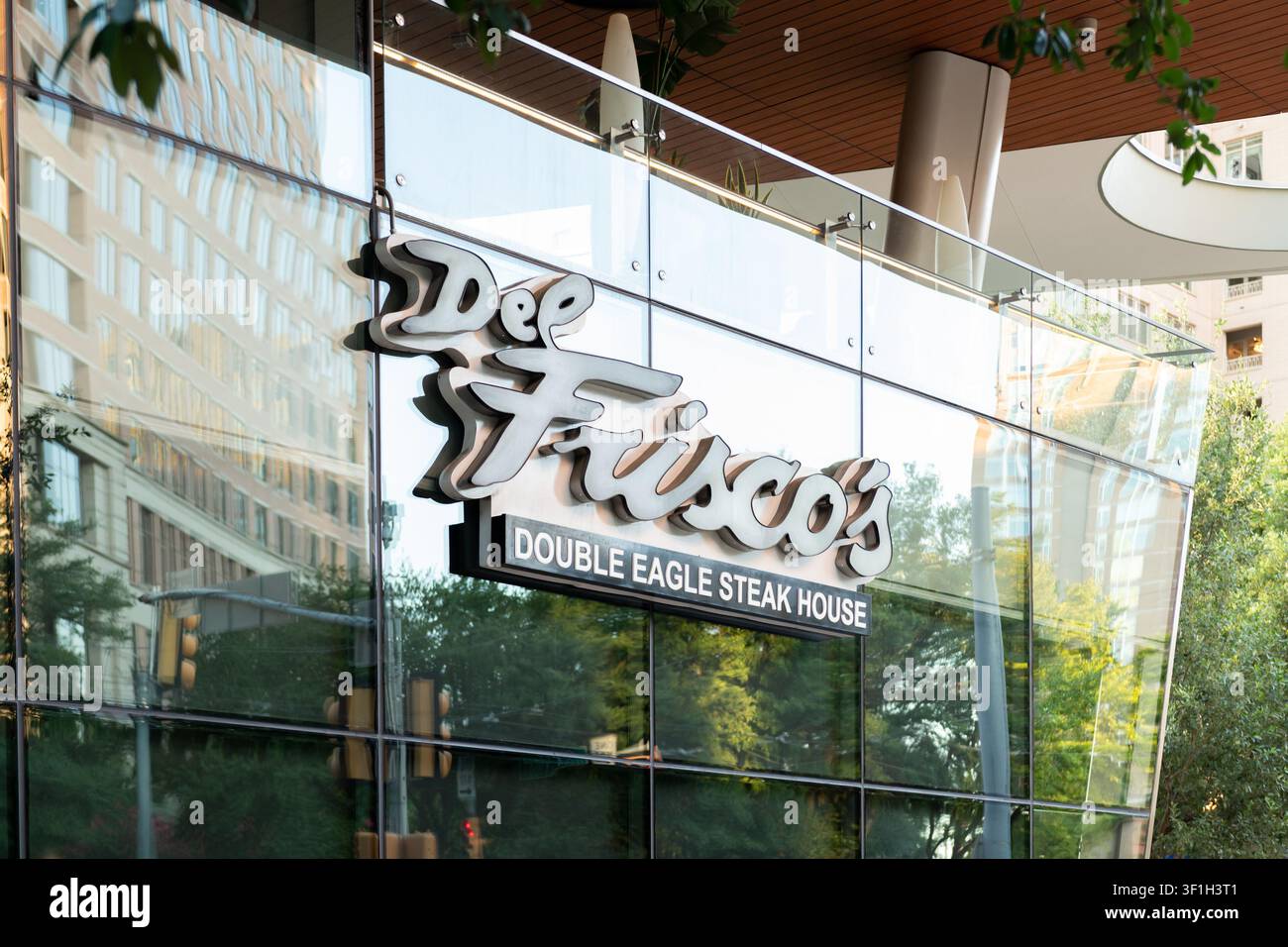 Außenzeichen für Del Frisco’s Double Eagle Steakhouse an einer reflektierenden Glasfassade in der Innenstadt von Dallas, Texas, USA. Stockfoto