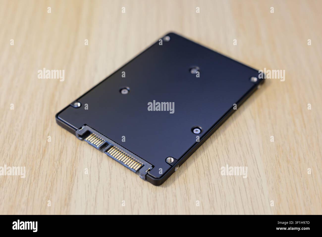 Interne SSD-Speicher mit SATA-Anschluss, die auf einem Tisch liegt. Nahaufnahme eines Computerteils. Flash-Laufwerk mit schnellen Lese- und Schreibgeschwindigkeiten. Stockfoto