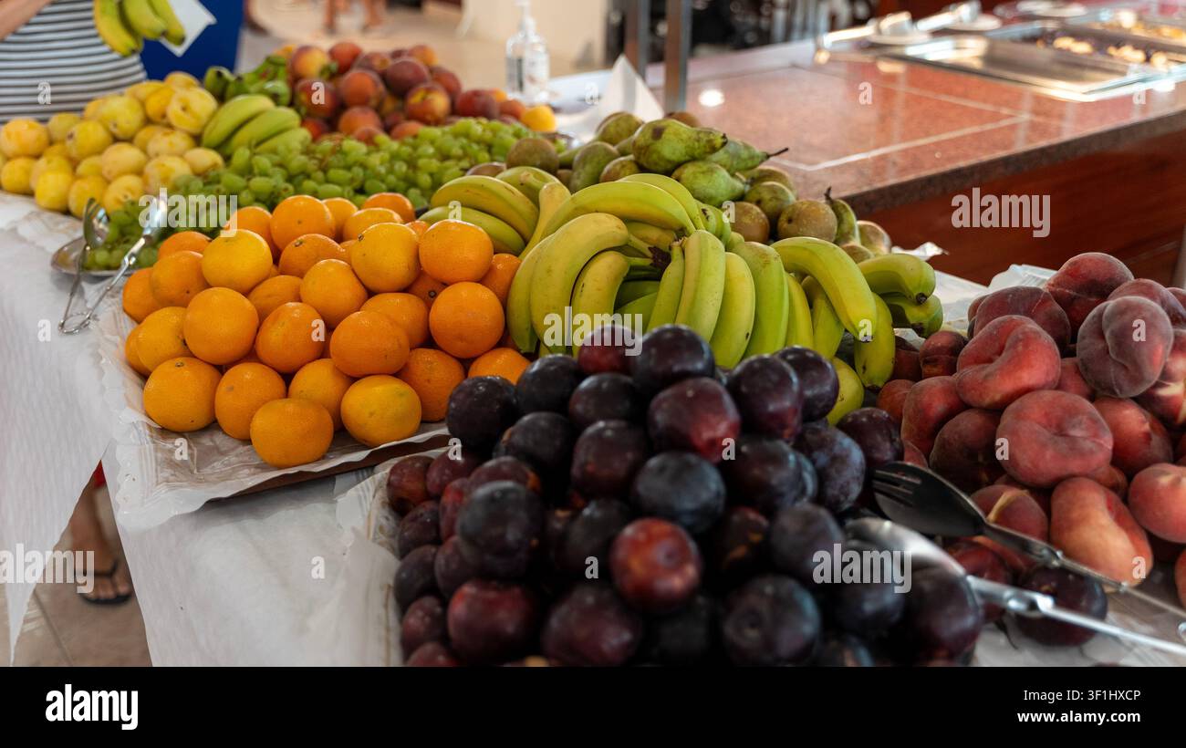 Frisches Obstbuffet mit Bananen, Orangen, Pflaumen, Pfirsichen und Trauben Stockfoto