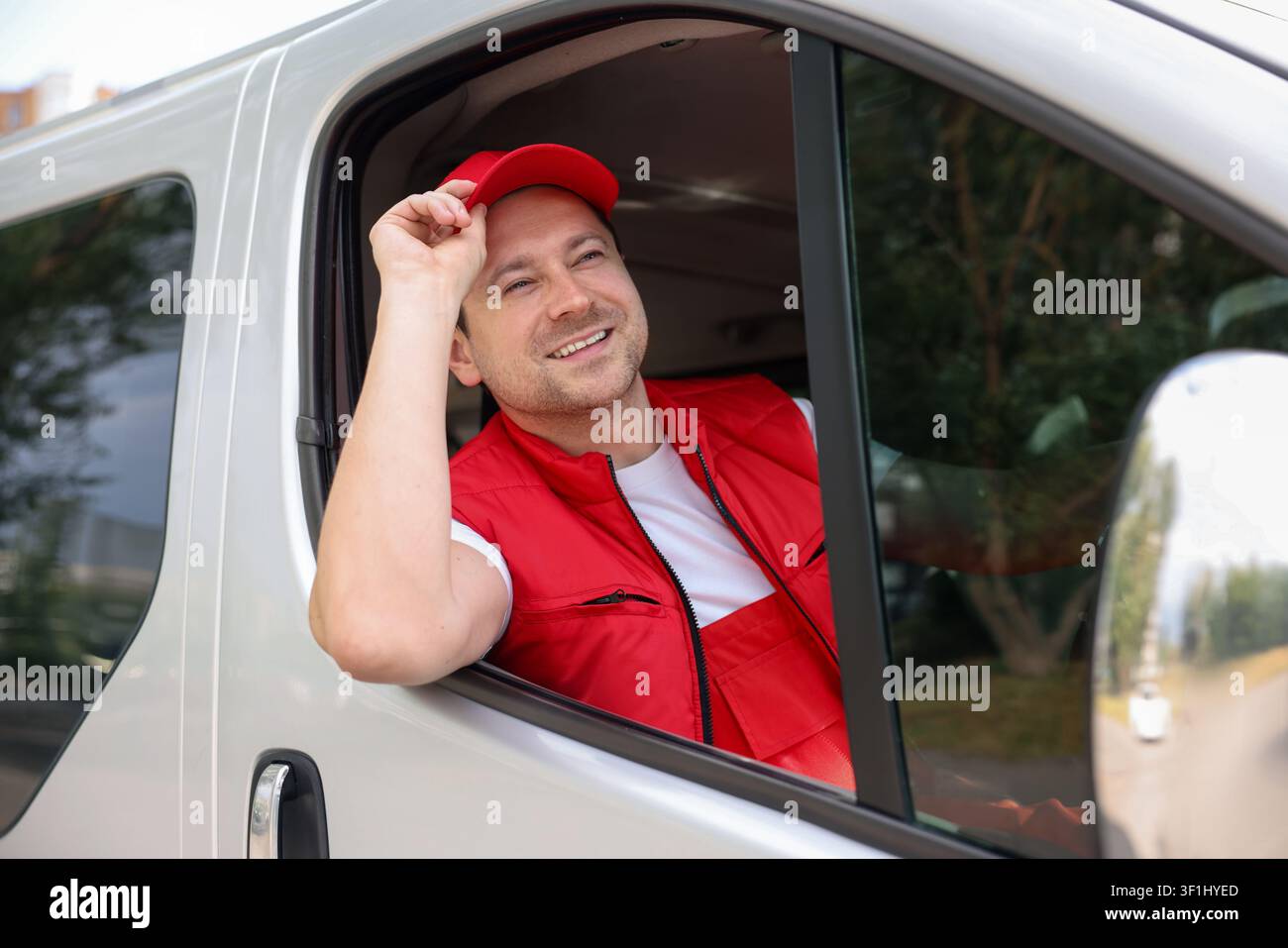Kurier in Uniform fährt Auto. Lieferdienst Stockfoto