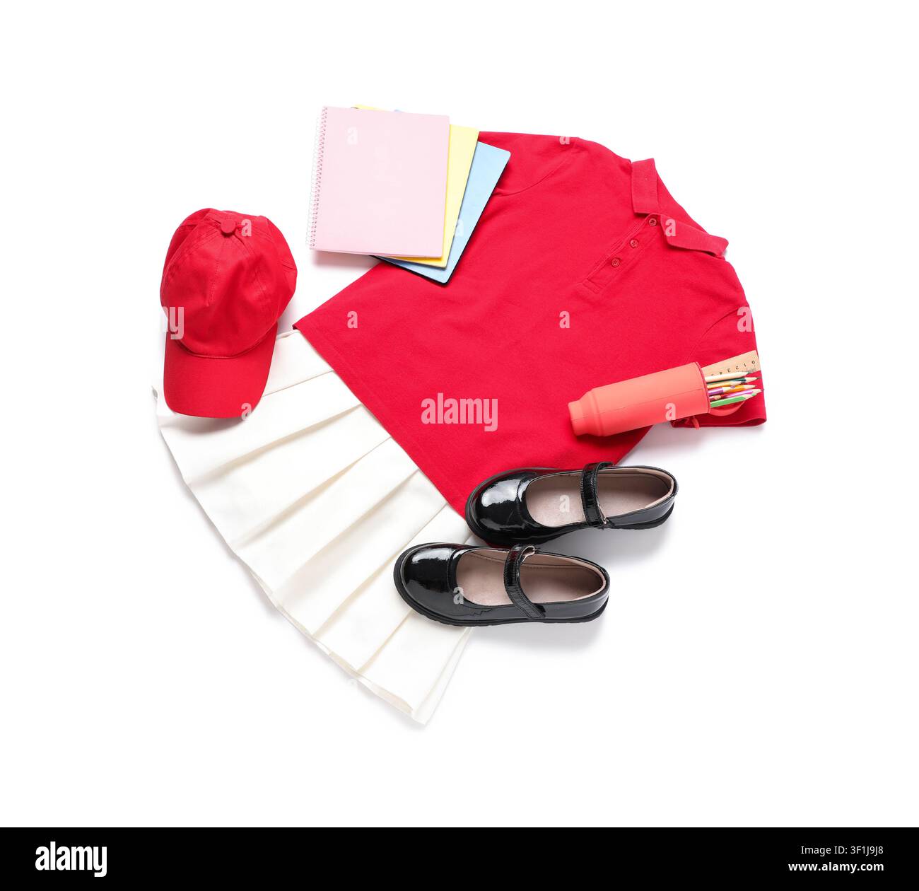 Rotes Polohemd, weißer plissierter Rock, schwarze Mary-Jane-Schuhe und Schulsachen für eine Kinderuniform, isoliert auf weißem Hintergrund Stockfoto