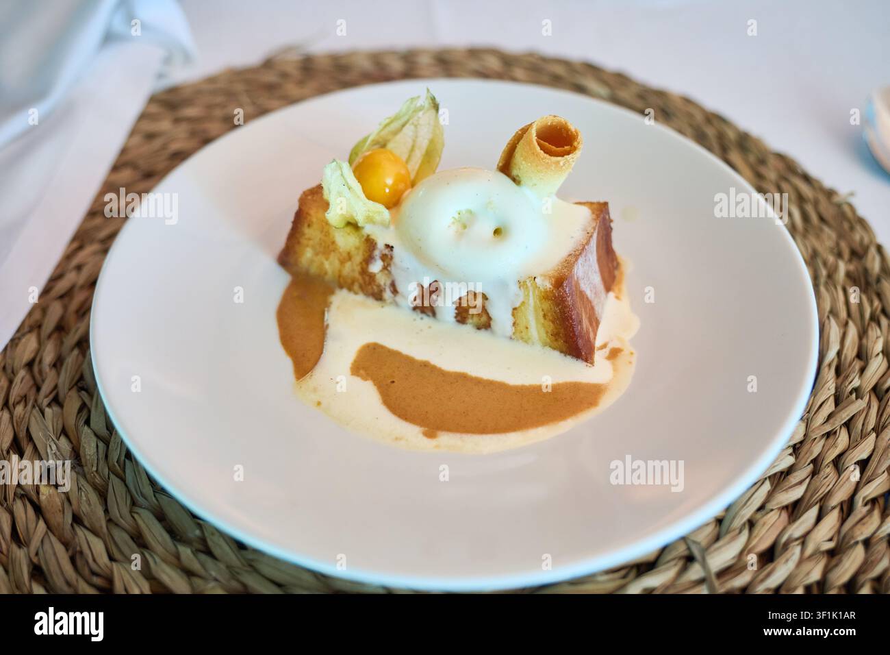 Französischer Toast-Dessert, der eine kulinarische Kombination aus süßen Aromen und Texturen präsentiert, garniert mit einer leichten Vanillecreme, einem knusprigen Waffel und frischem Stockfoto