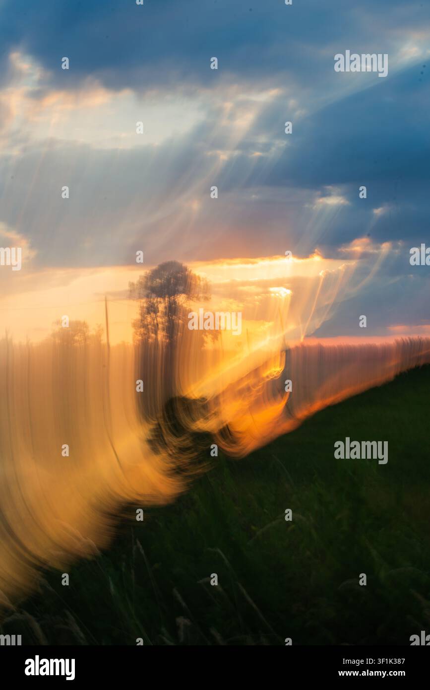 Abstrakte ICM-Bewegungsunschärfe, aufgenommen während des Sonnenuntergangs mit fließenden Lichtstrahlen und weicher Textur in lebhaften orangefarbenen und blauen Sonnenuntergangsfarben. Konzeptuell. Stockfoto