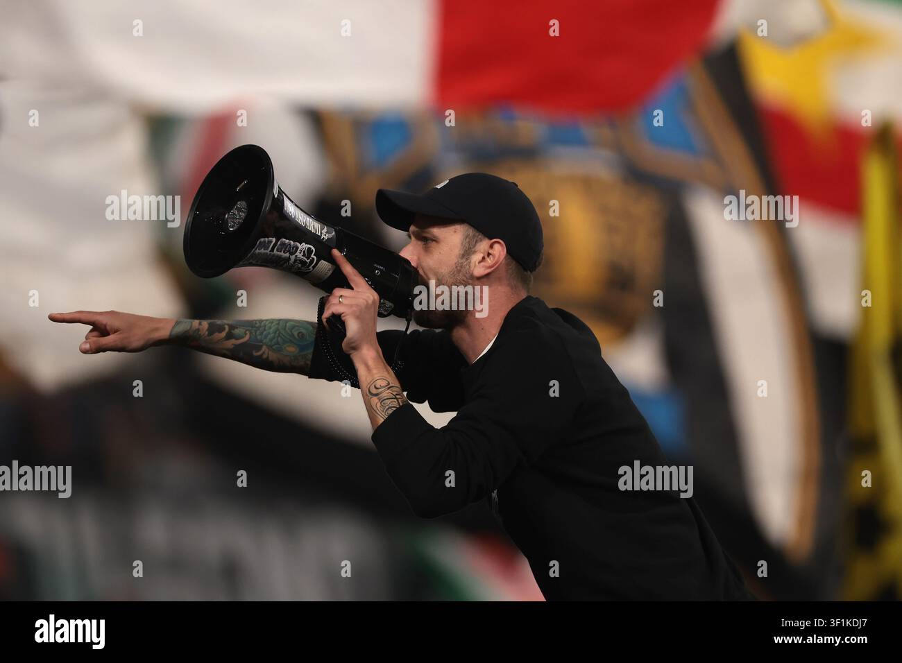Ein Fan benutzt ein Megafon, um seine Mitfans aufzufordern, das Team während des Spiels zu unterstützen. Stockfoto