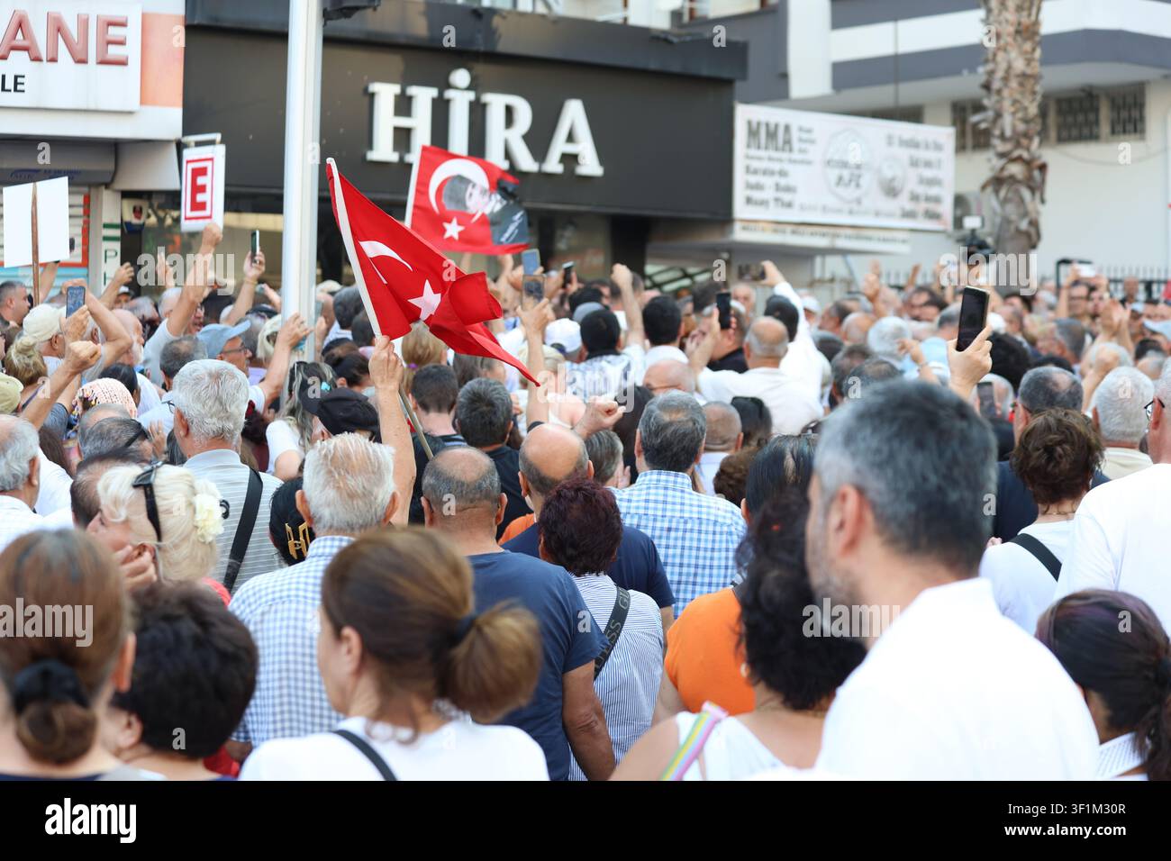 Mehrgenerationen-Menge von Anhängern, die Fahnen schwenken, um den CHP-Führer Özgür Özel in Adana, Türkei, zu begrüßen Stockfoto