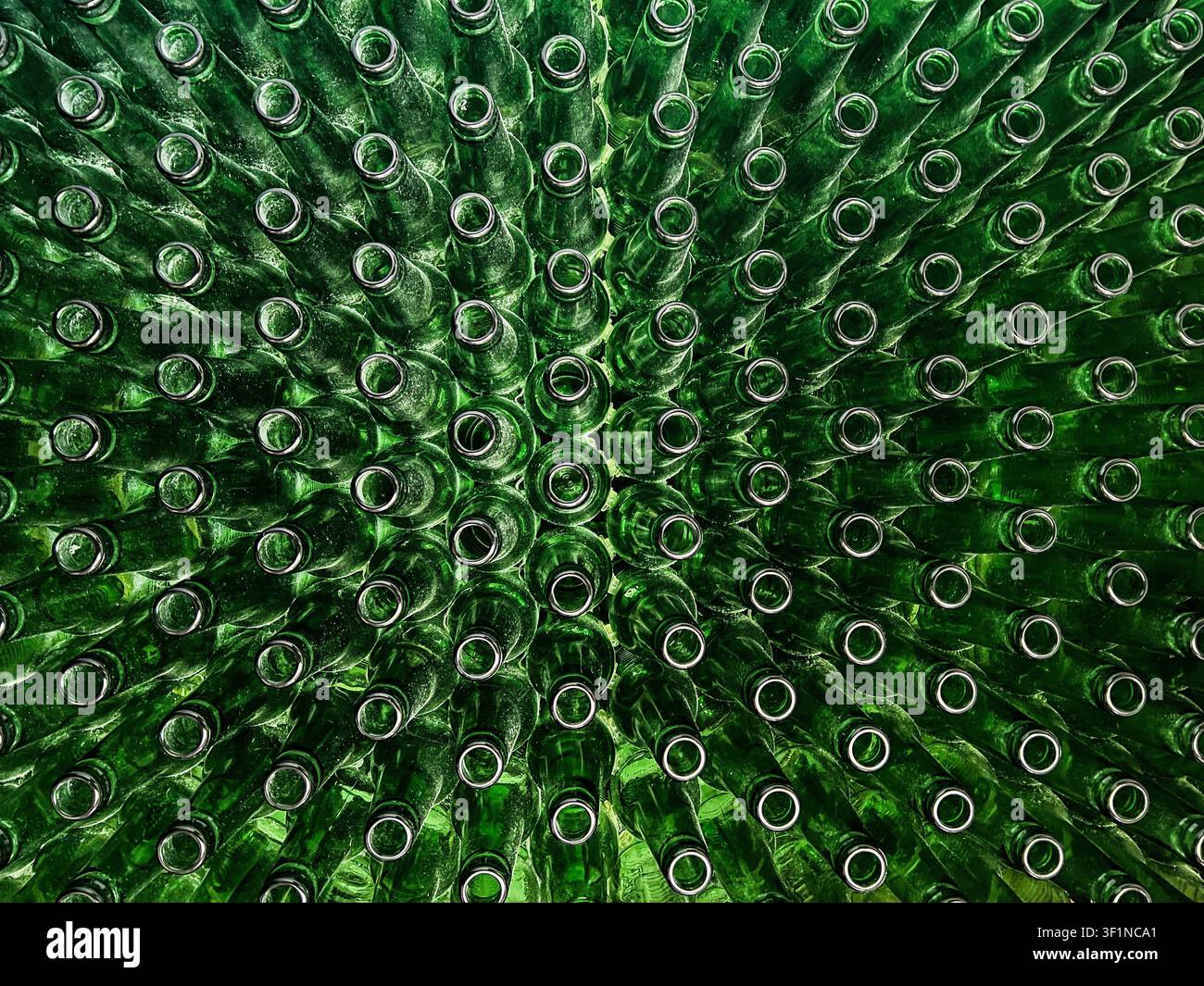 Abstrakter Hintergrund aus grünen Glasflaschen. Konzept des Glasrecyclings, wiederverwendbarer Flaschen, Kreislaufwirtschaft, Flaschenpfandsystem (Pfand) und s Stockfoto