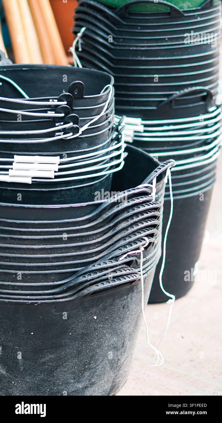 Ein Stapel schwarzer Plastikeimer mit Metallgriffen Stockfoto