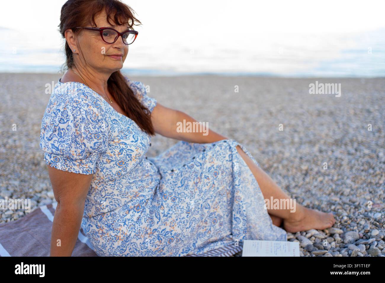 Frau liest ein Buch am Strand Stockfoto