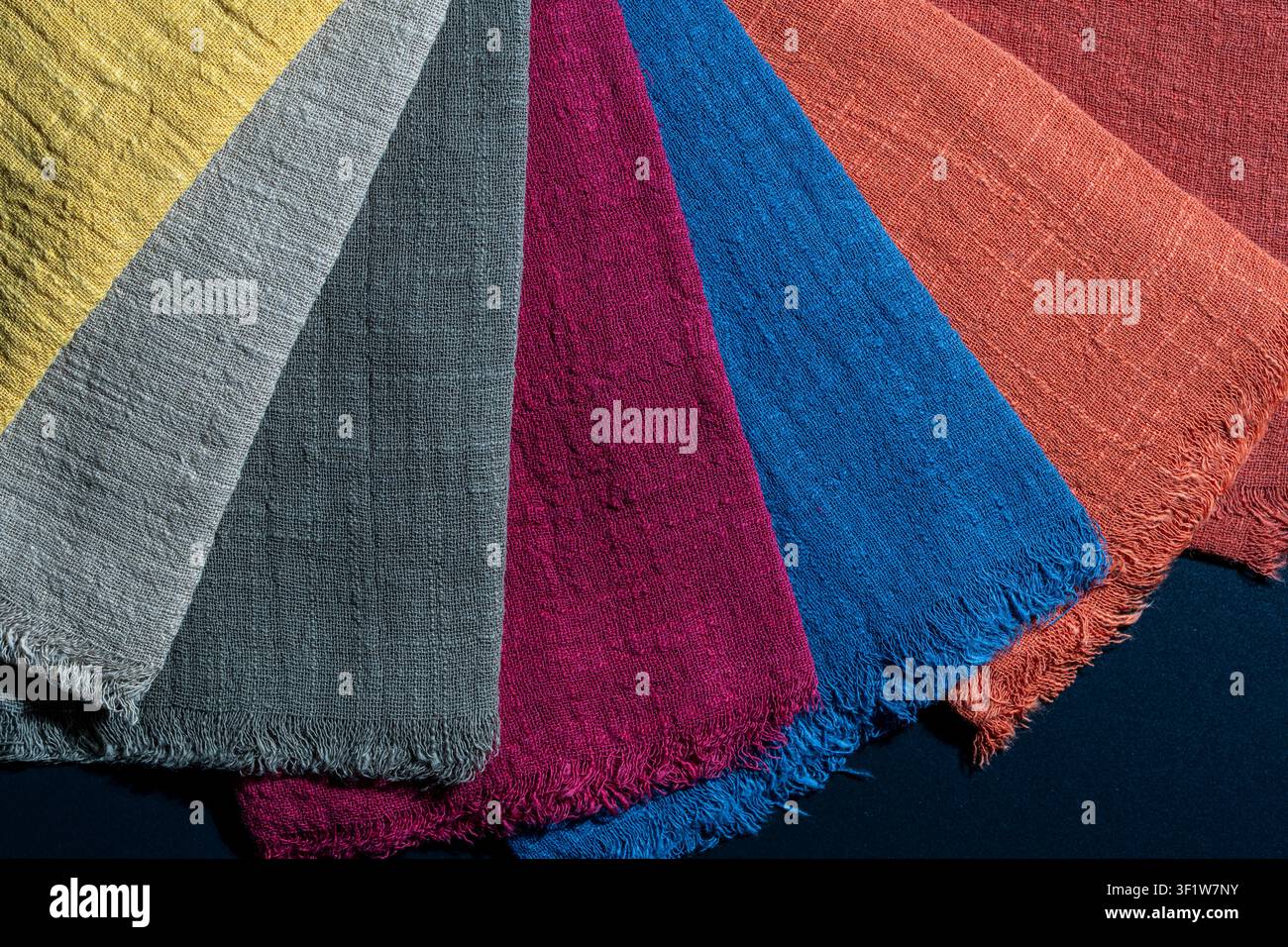 Bunte Leinenstoffmuster. Fächerauswahl an texturierten Leinenstoffproben in verschiedenen lebendigen Farben, die die Materialqualität für Mode, Textil zeigen Stockfoto