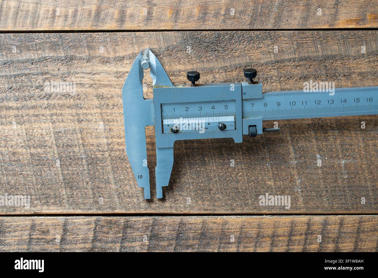 Schnellspannzirkel, ein Präzisionslängenmessgerät auf einem Arbeitstisch aus Holz. Der Schnellspannzirkel ist ein hochgenaues Messgerät. Die exakte Größe des Par Stockfoto