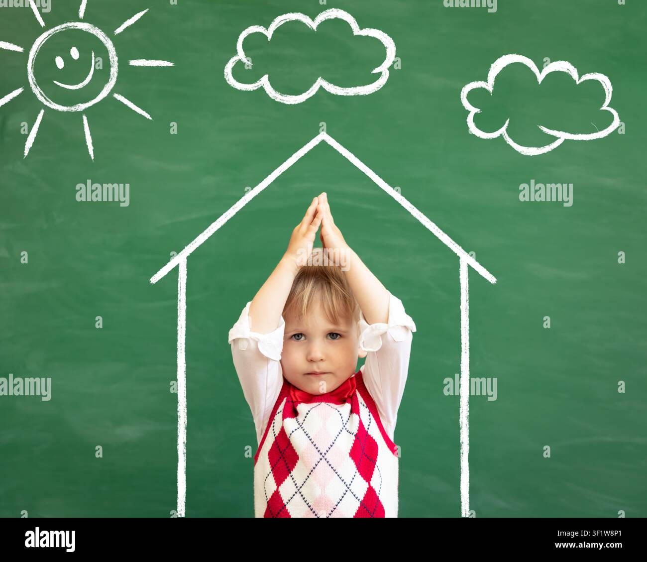 Trauriger Kinderschüler im Unterricht. Ernstes Kind vor grüner Tafel. Bleib-zu-Haus-Konzept. Zurück zur Schule Stockfoto