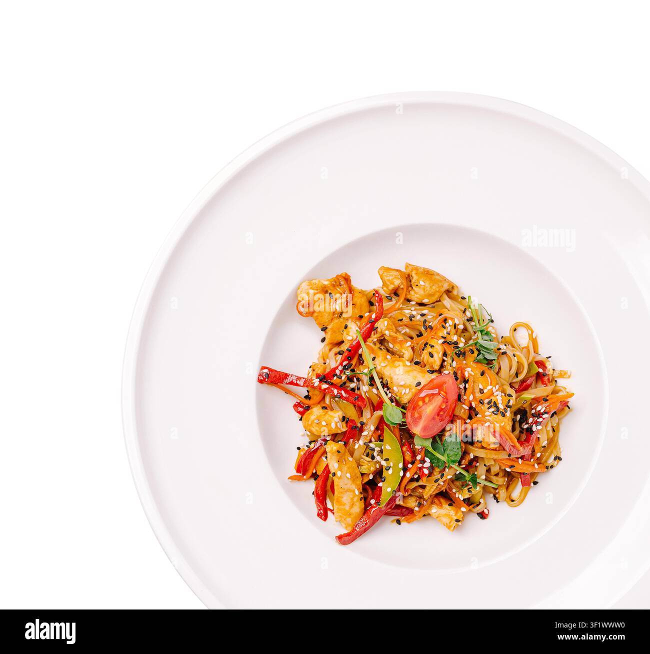 Teller mit asiatisch gebratenen Udon-Nudeln mit Huhn, Gemüse und Sesamsamen Stockfoto