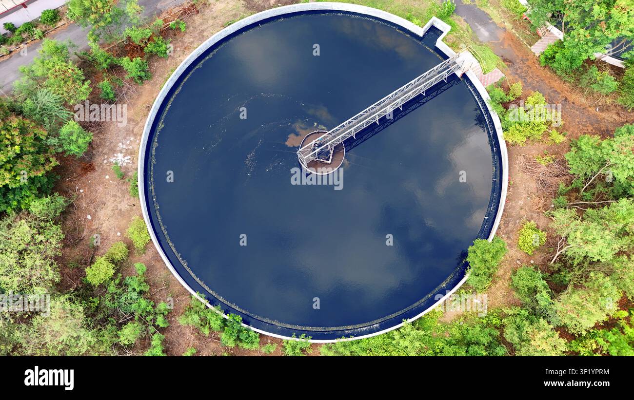 Vertikale Drohnenansicht eines großen runden Sedimentationsbeckens mit Wasserreflexion Stockfoto