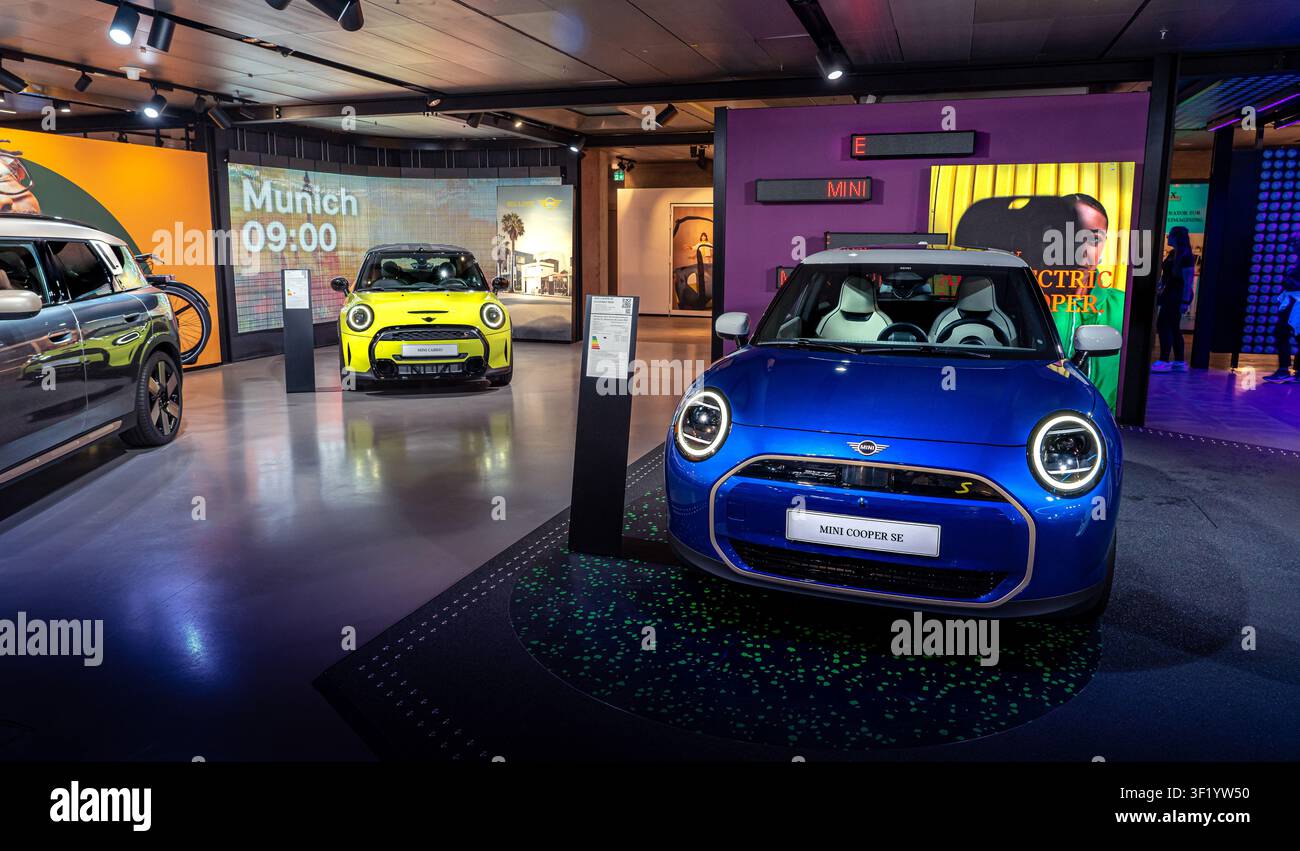 Ikoniisches Modernes Mini Cooper Auto fährt auf einer malerischen Stadtstraße Stockfoto