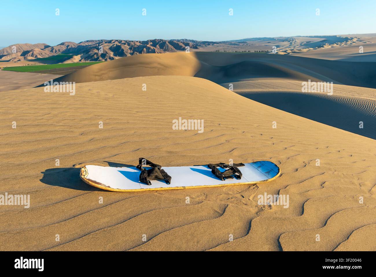 Sandboard bei Sonnenuntergang in der Nazca-Wüste nahe Ica, Peru. Stockfoto