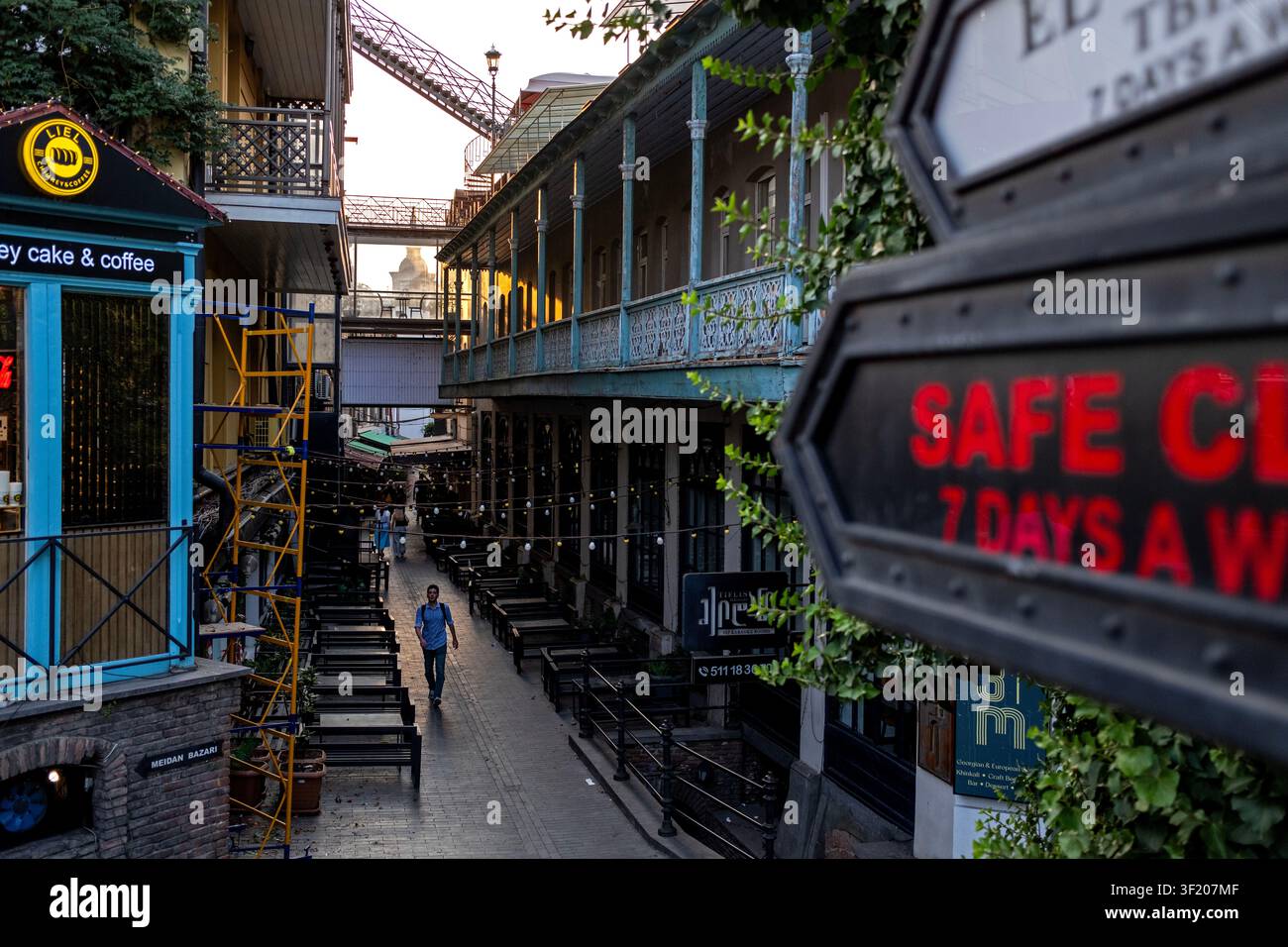 Ein Mann geht an einem heißen Sommertag durch eine Gasse in Tiflis, Georgien. Stockfoto