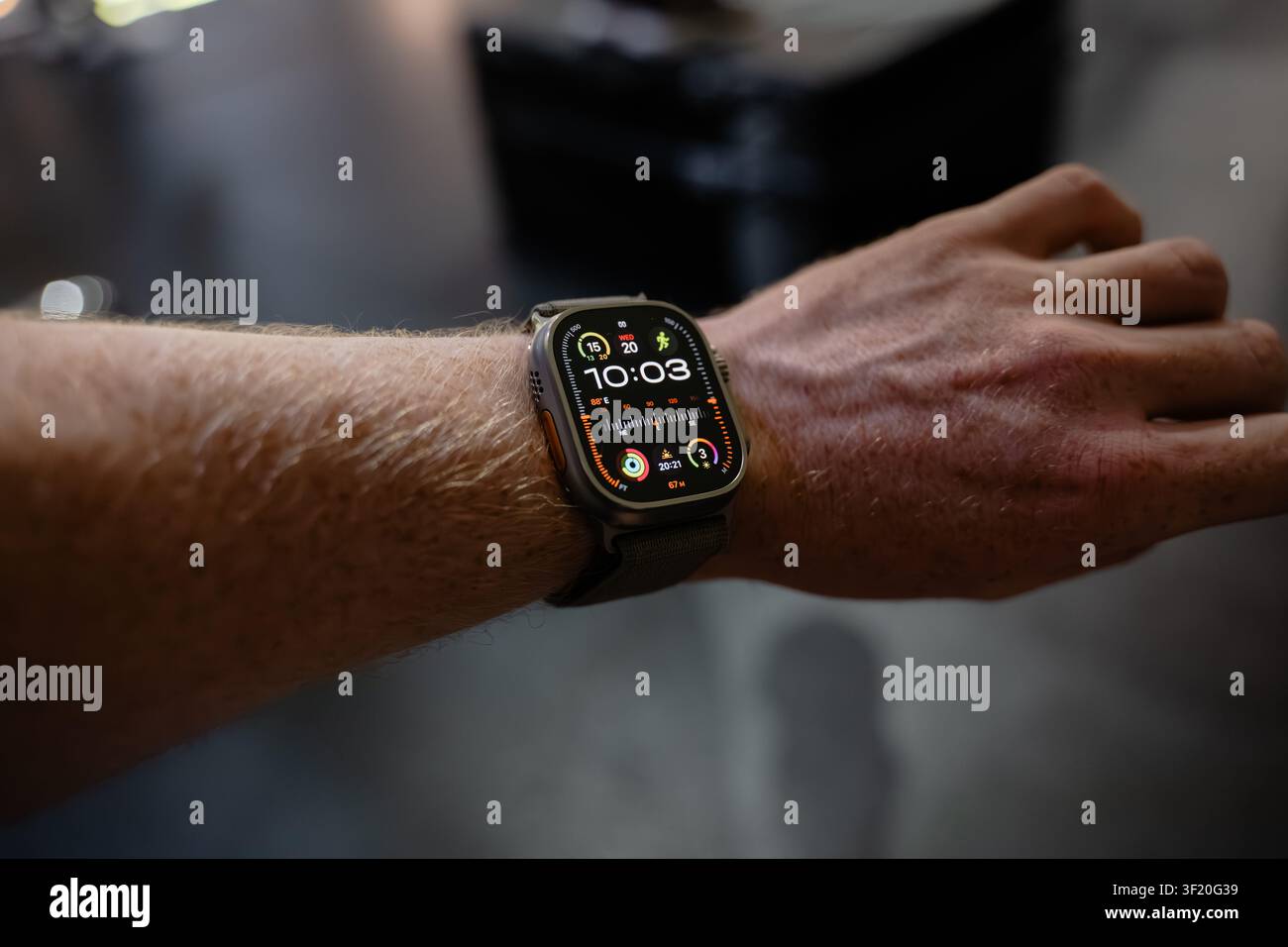 Nahaufnahme einer Smartwatch am Handgelenk einer Person. Uhrzeit und Wetteranzeige deutlich sichtbar. Hand entspannt, was den lässigen Gebrauch nahelegt. Bild geeignet für Technik oder Stockfoto