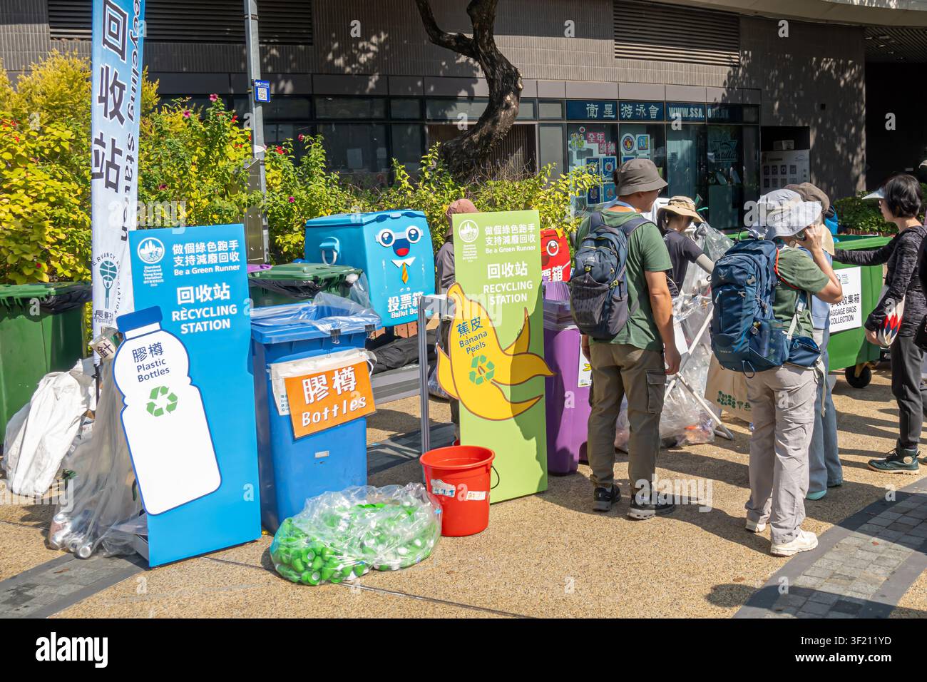Mehrkategorien-Gemeinschafts-Mülltrennungs- und Recyclingstation in Hongkong, farbcodiert und mit traditionellem Chinesisch und Englisch beschriftet Stockfoto