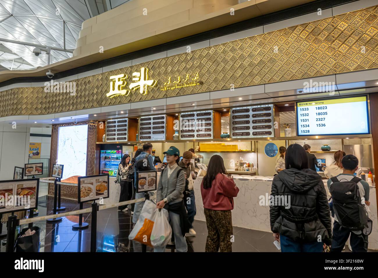 Leckerer Congee- & Nudeln-Wantun-Laden im Abflugbereich des Hong Kong International Airport. Das Restaurant spezialisiert sich auf kantonesische Küche Stockfoto