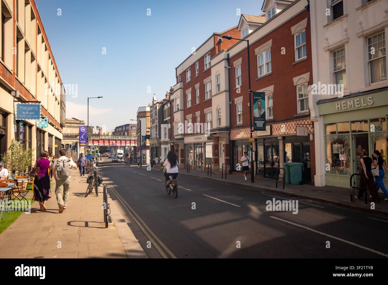 LONDON – 27. MAI 2026: Parsons Green High Street – Sonnige Straßenszene mit Fußgängern in der Nähe der District-Line-Station, Fulham. Stockfoto