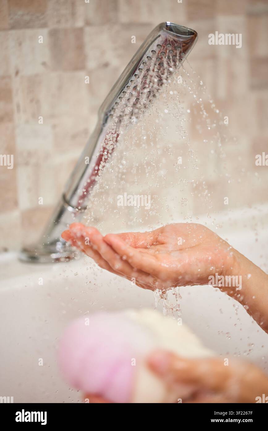 Hände, die Duschwasser für die Hygiene-Routine auffangen Stockfoto