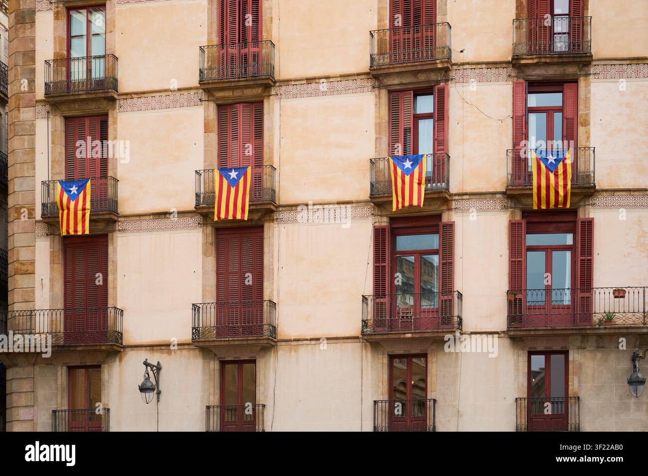 Historische Wohnhausfassade mit katalanischen Flaggen an den Balkonen in Barcelona Stockfoto