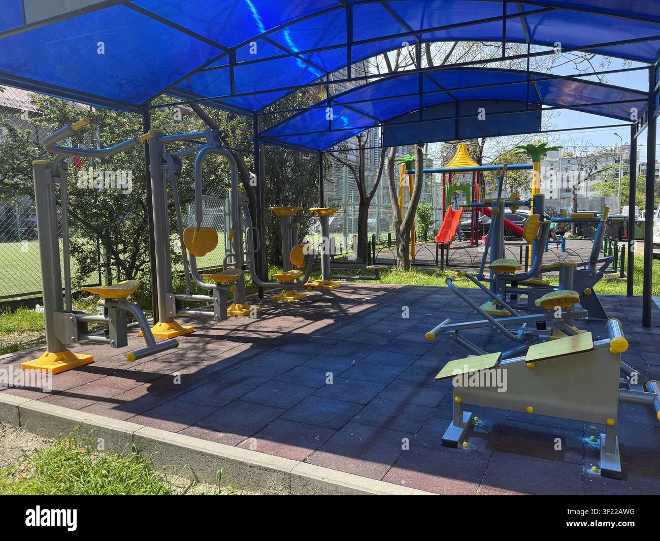 ein Spielplatz mit einem blauen Vordach und einer gelben Rutsche Stockfoto