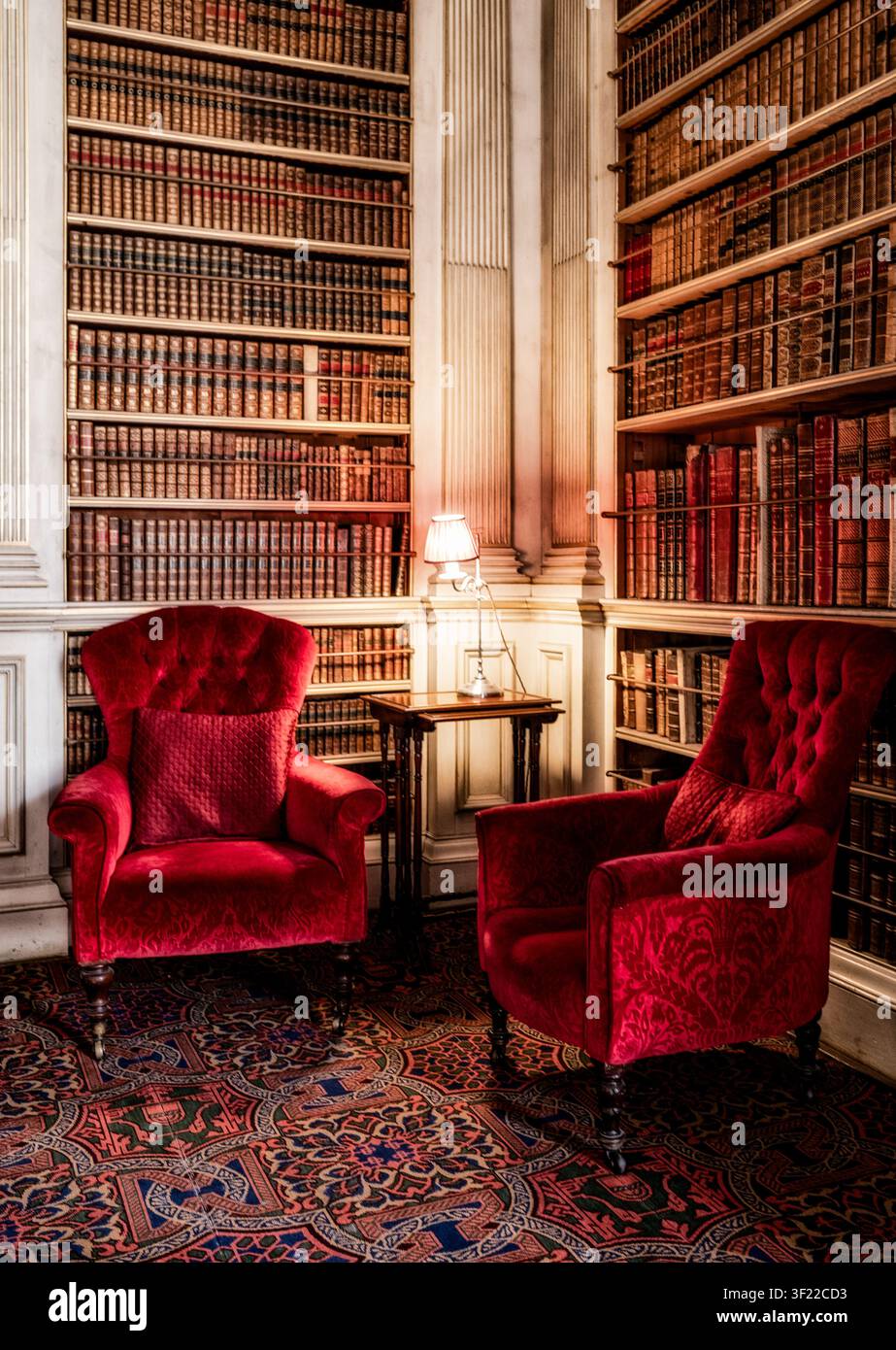 Rote Armchairs in der Bibliothek eines englischen Landhauses in Essex Stockfoto