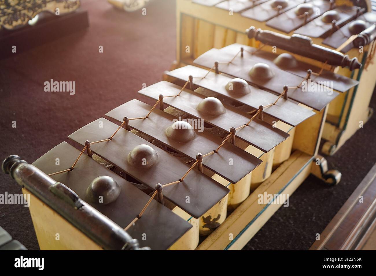 Detaillierte Ansicht eines traditionellen indonesischen Gamelan-Metallophons mit Bronzeplatten und Holzrahmen Stockfoto