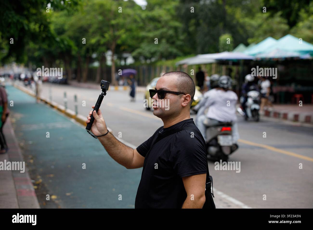 BANGKOK, THAILAND - 12. JULI 2026: Mann, der eine Vlogging-Kamera benutzt, Rückansicht. Stockfoto