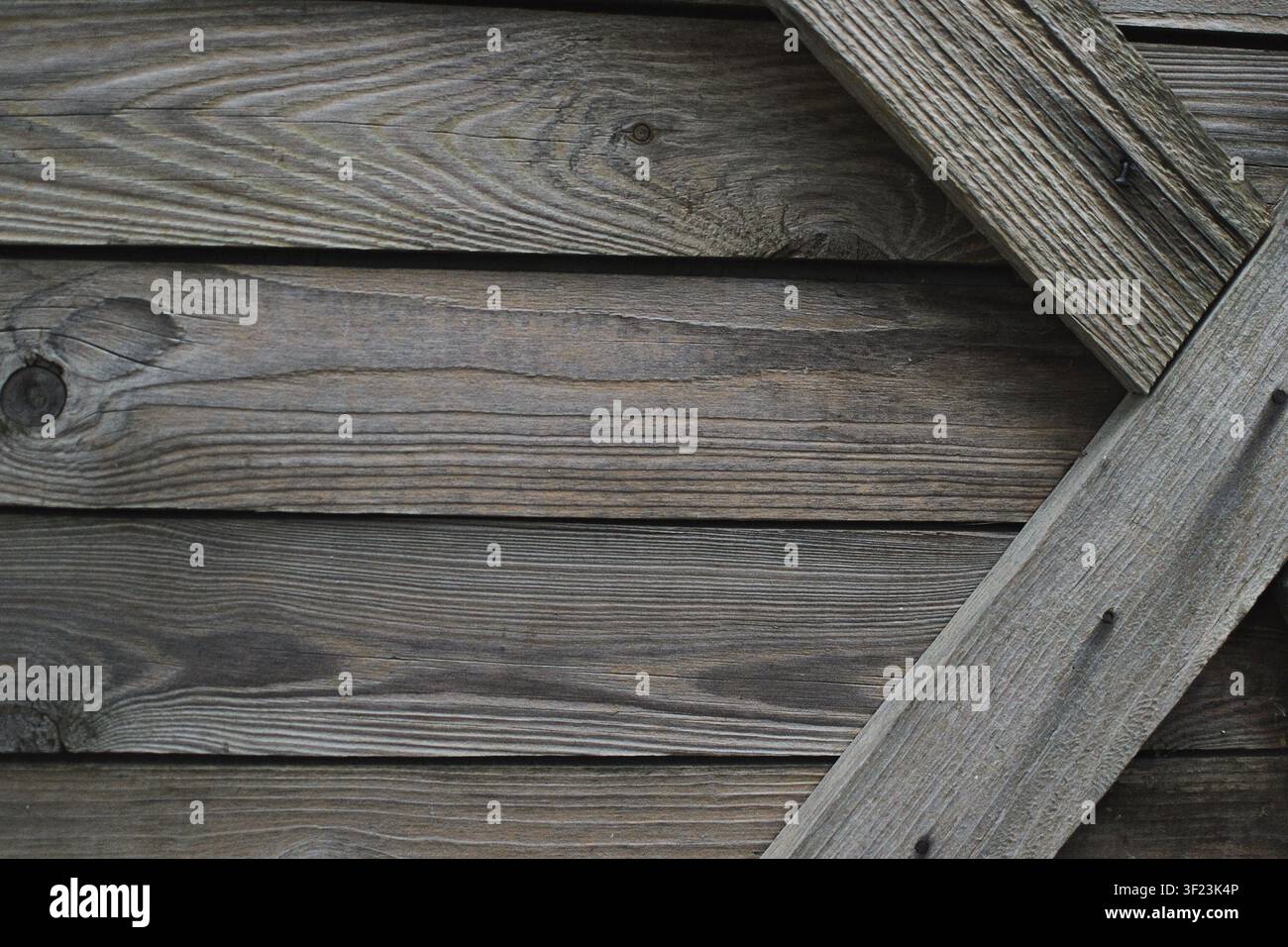 Verwitterte Holzplanken mit einem diagonalen Brettdetail in Nahaufnahme. Rustikale Holztexturhintergrund für Bau, Design, Möbel und Natur Stockfoto