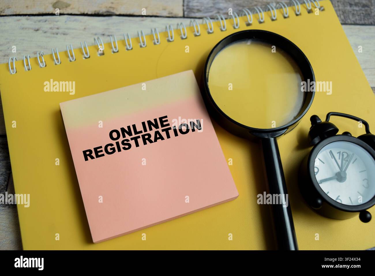 Konzept der Online-Registrierung, geschrieben auf Haftnotizen, isoliert auf Holztablett. Stockfoto