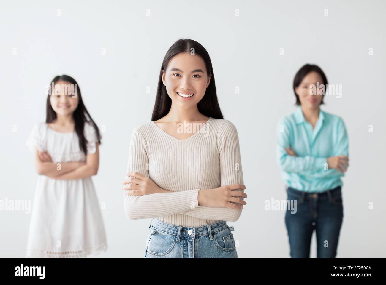 Lächelnde asiatische Frau steht selbstbewusst vor Freunden, positives Gruppenumfeld Stockfoto
