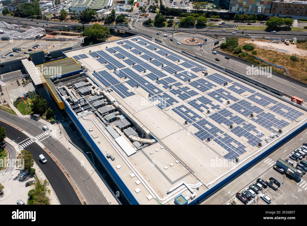 Drohnenansicht eines Einkaufszentrumsdachs, das mit Solarpanelen für die Erzeugung erneuerbarer Energien bedeckt ist. Stockfoto