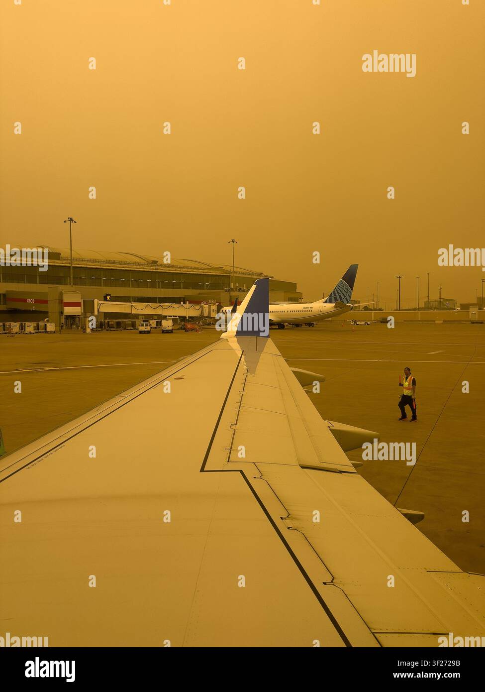Flughafen-Bodenpersonal und United-Airlines-Flugzeug auf der Rollbahn am Toronto Pearson International Airport YYZ, umhüllt von Waldbrandrauch Stockfoto