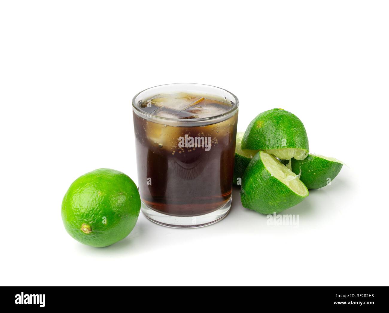 Cola-Whisky-Cocktail, Cuba Libre mit Rum, Cola und Limette, Auspressen einer halben grünen Zitrone auf weißem Hintergrund, Burnout-Symbol, Herstellung von Eiskühlalkohol Stockfoto
