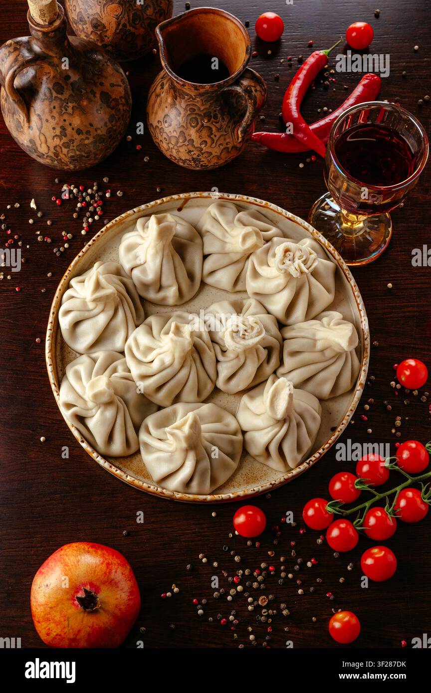 Georgische Khinkali-Dumplings mit Wein auf einem rustikalen Tisch Stockfoto
